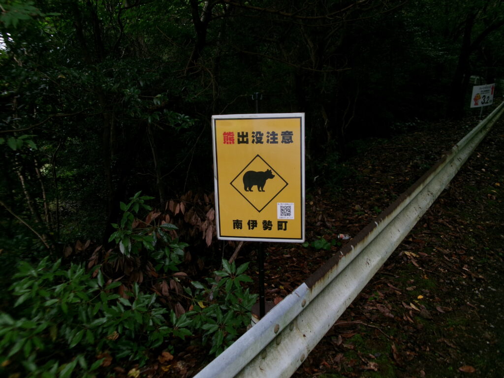 贄浦漁港対岸の道路。クマ出没注意の看板あり。