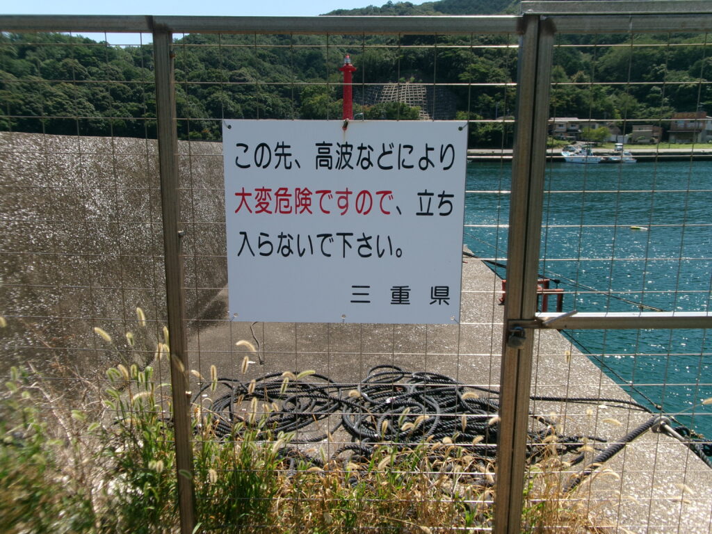 2025年8月20日に行った現地調査時の防波堤の写真。北側堤防を写したものだが、フェンスと立て看板で先端方向へは進めなくなっているのがわかる。