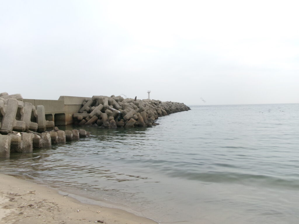 河芸漁港南にある砂浜から撮影した防波堤の写真