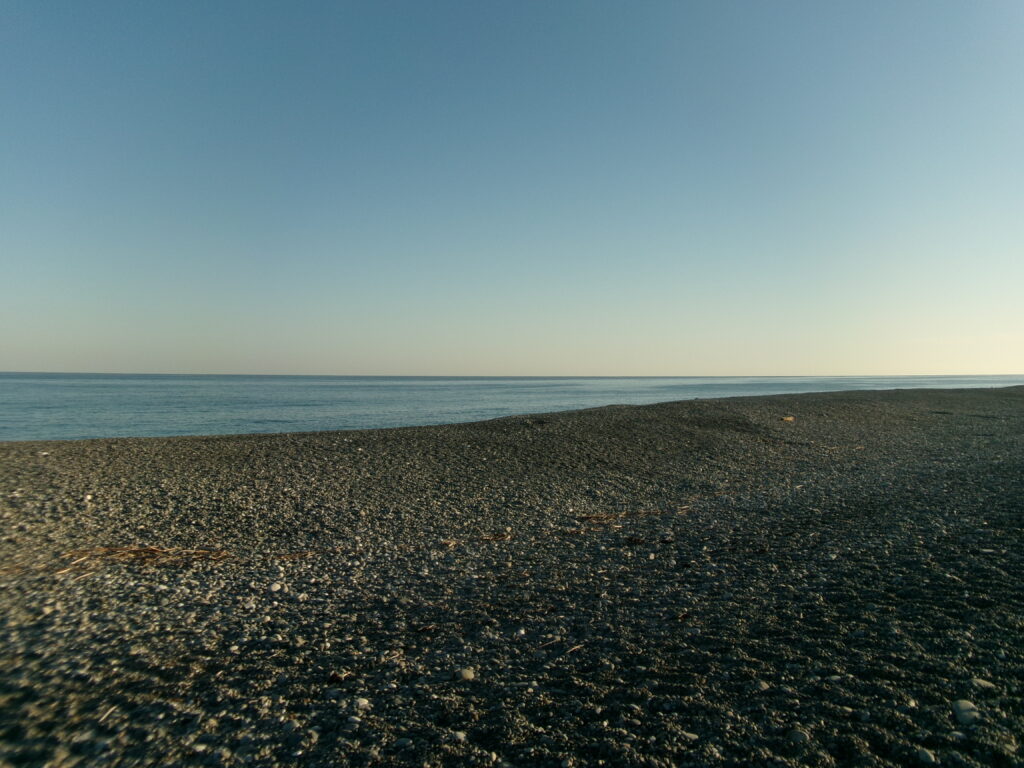 現地調査で撮影した、七里御浜海岸の釣り場の写真。玉砂利の海岸が続く様子が見られる。