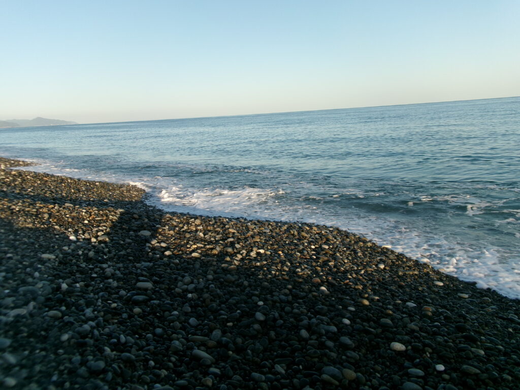 現地調査で撮影した、七里御浜海岸の釣り場の写真。玉砂利の海岸が続く様子が見られる。